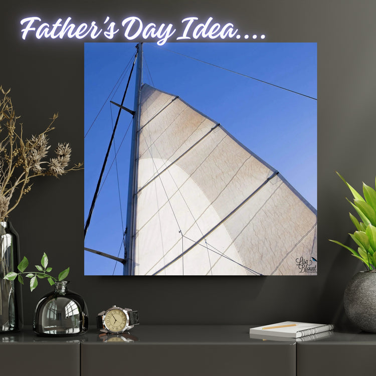 best Father’s Day gift idea - fine art - of sailboat sail and mast looking upward to a blue sky.  Art hanging on wall above masculine shelf.