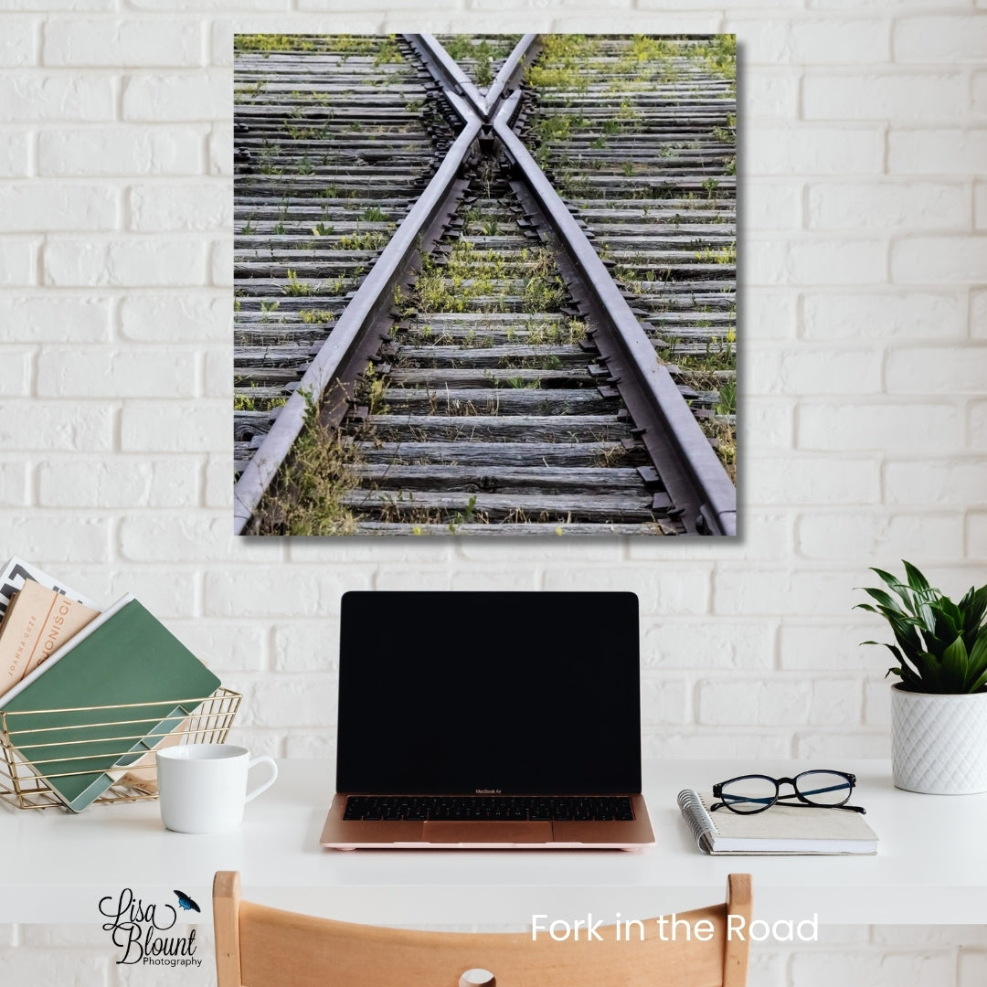 Brushed metal train tracks fine art photography wall decor hanging in Office with white brick wall.