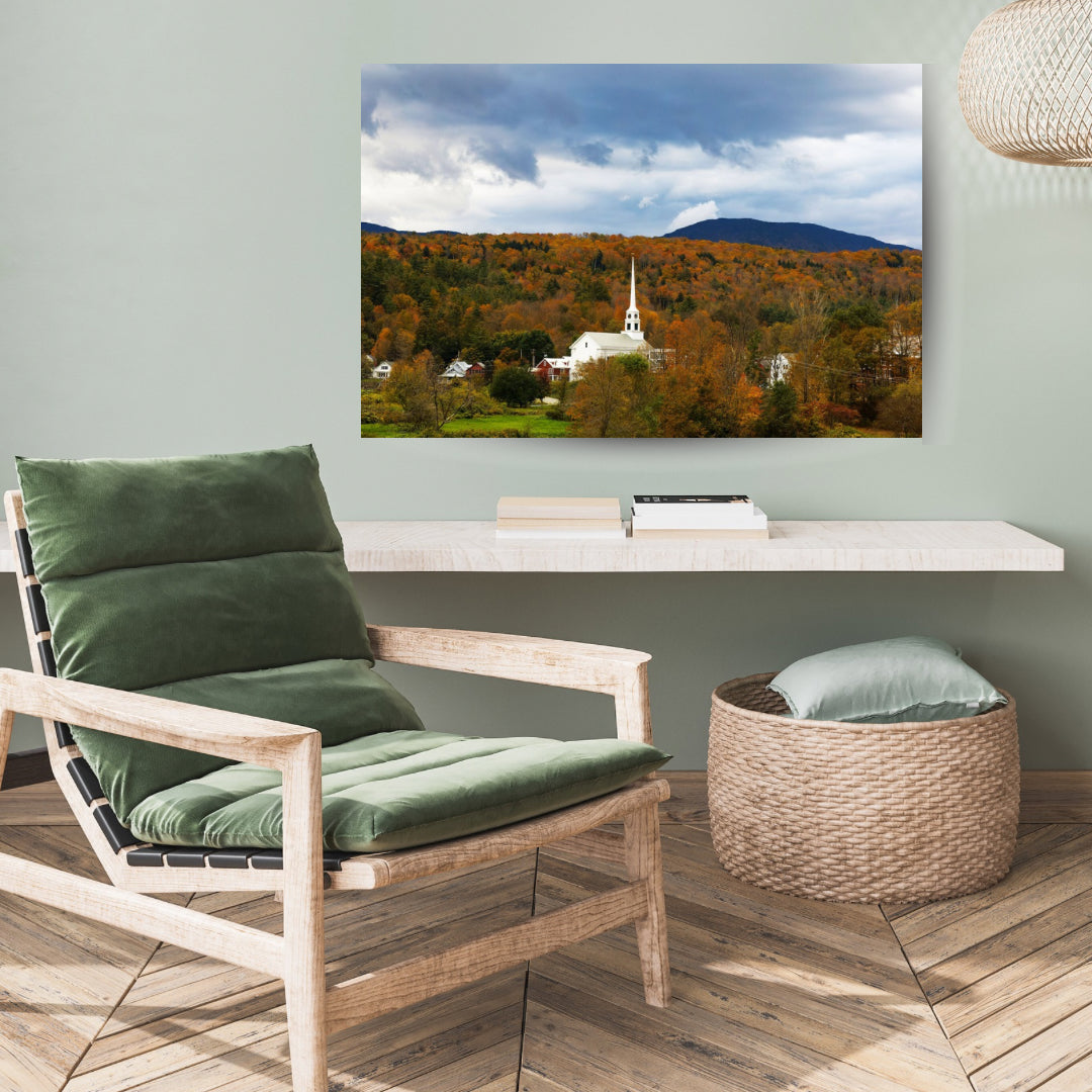 Stowe Vermont’s white church in the fall with orange leaves. Large 30x20 canvas print featured in a casual green room.