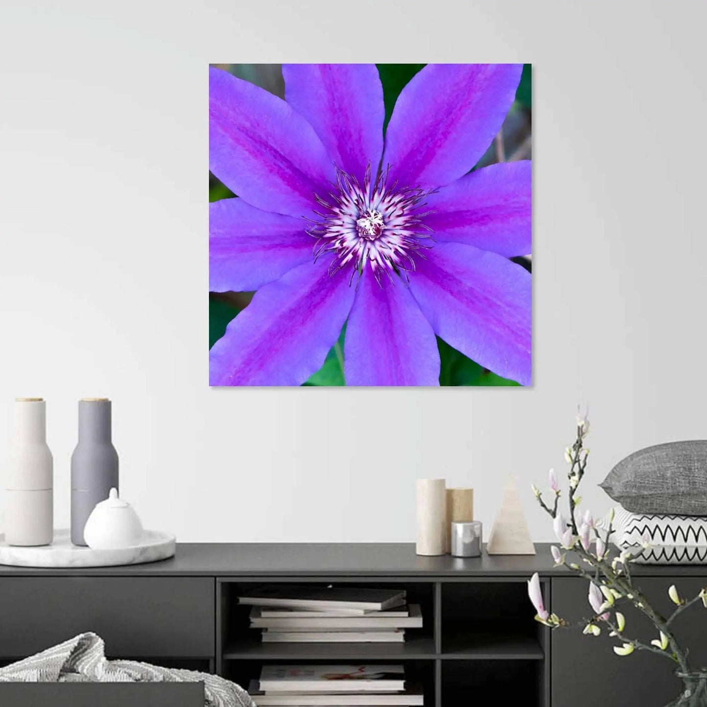 Purple clematis flower art hanging above a grey cabinet on a white wall