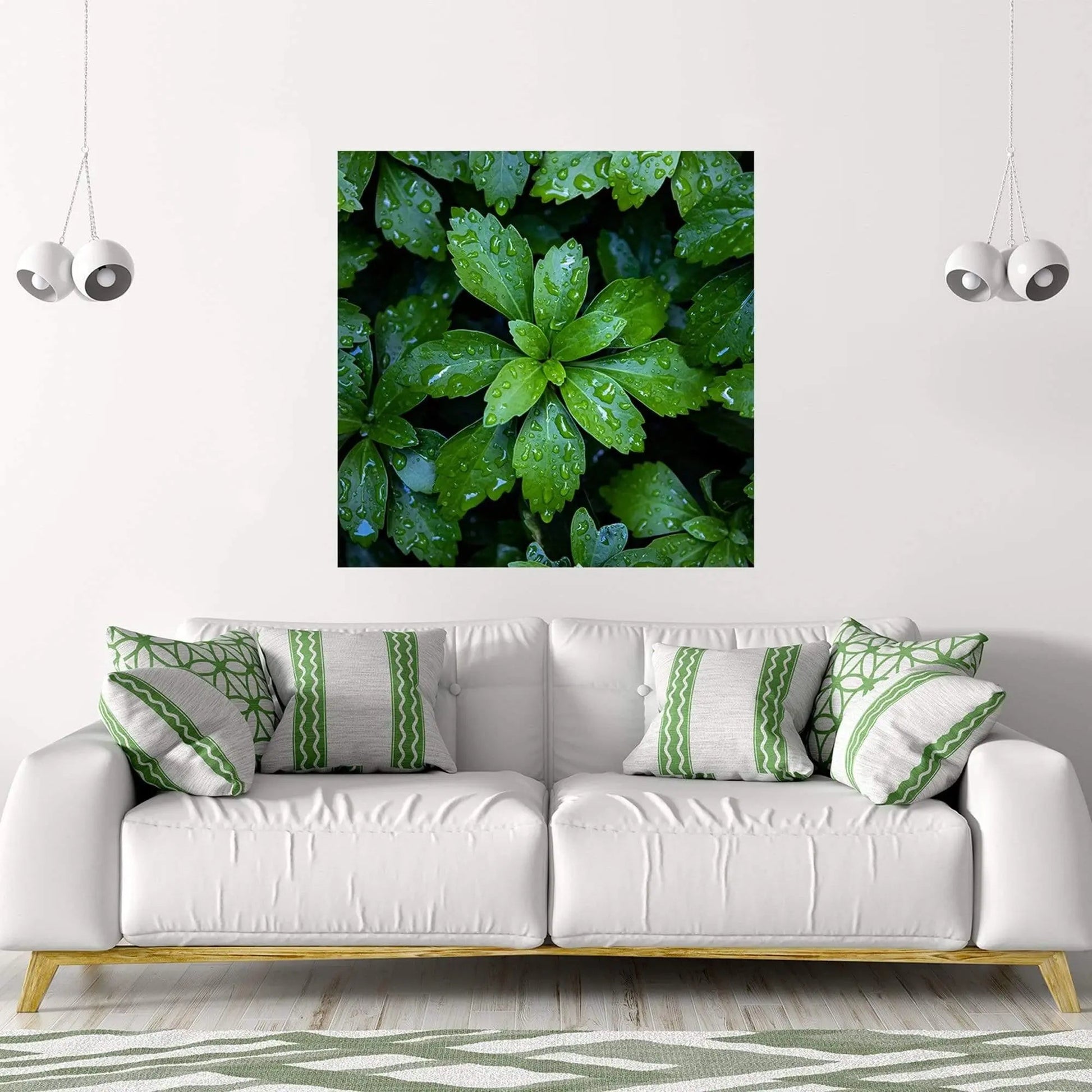 Art of bright green leaves covered in raindrops is the focus over a white couch with green accent pillows