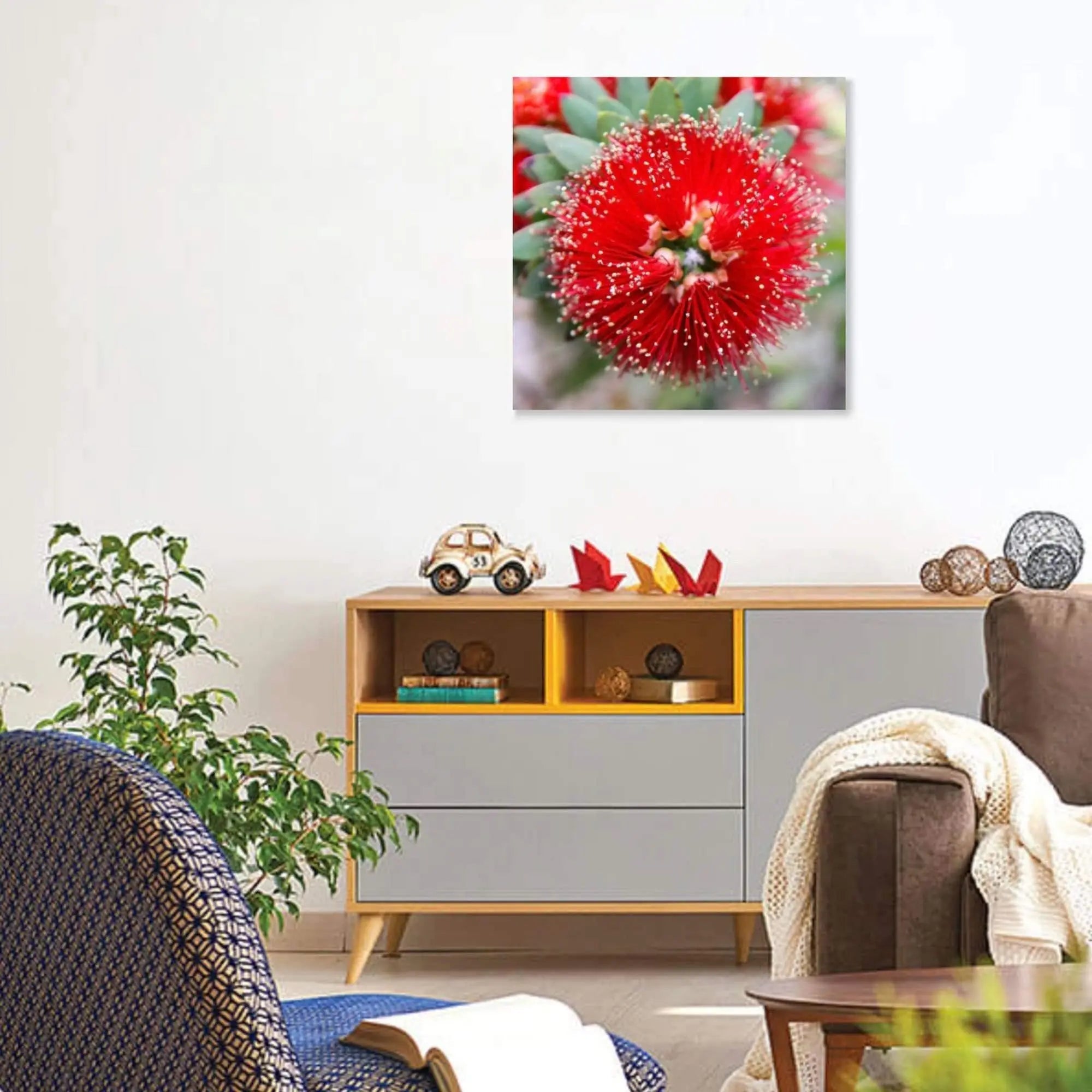 Red bottlebrush floral wall art styled in a warm, mid-century modern living room with a gray sideboard and decor accents.