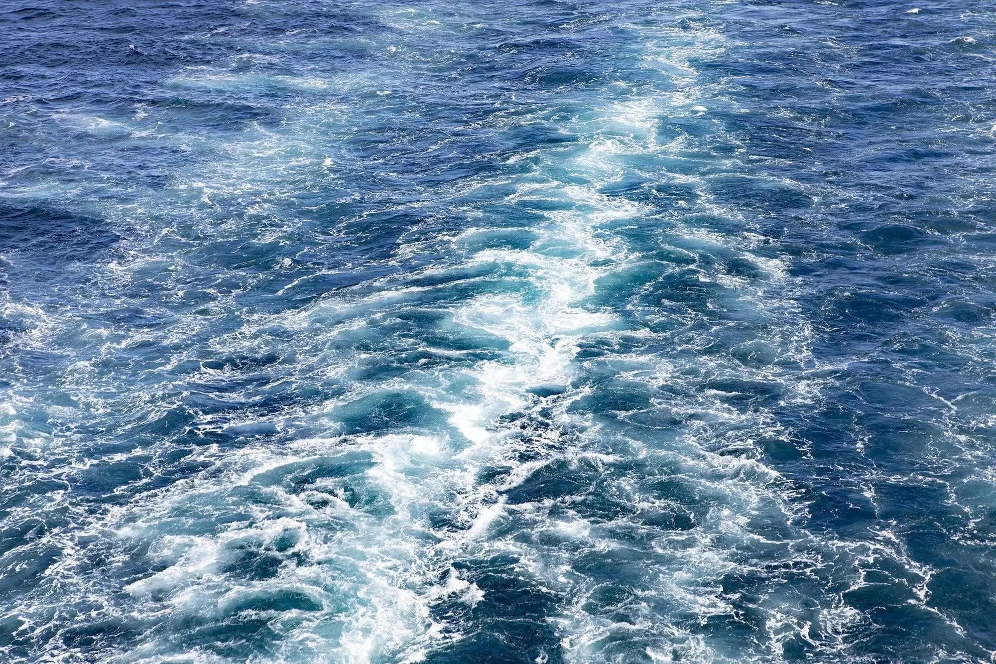 Blue ocean wall art printed on acrylic featuring abstract swirling turquoise and deep blue waves