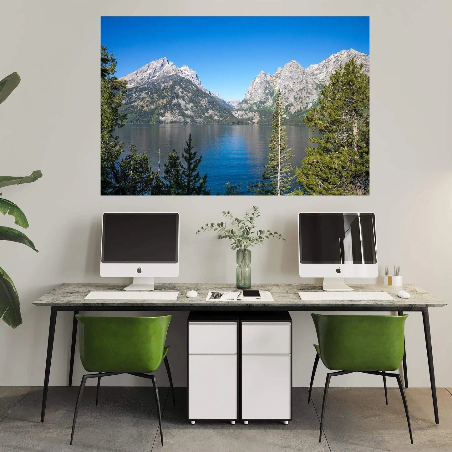 Large art of cloudless Jenny Lake in Grand Teton National park hanging above a minimalistic office above a desk with 2 computers.