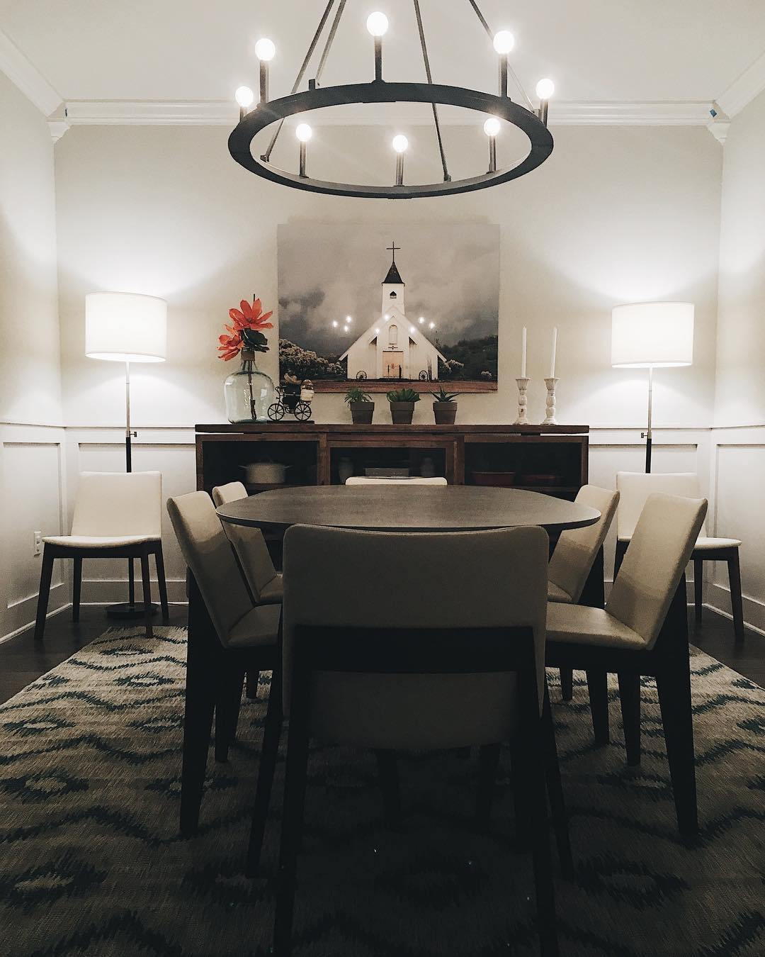 “Spiritual Warfare” white church wall art styled in an elegant dining room by Ashley Cardiel Interiors, illuminated by a modern chandelier.