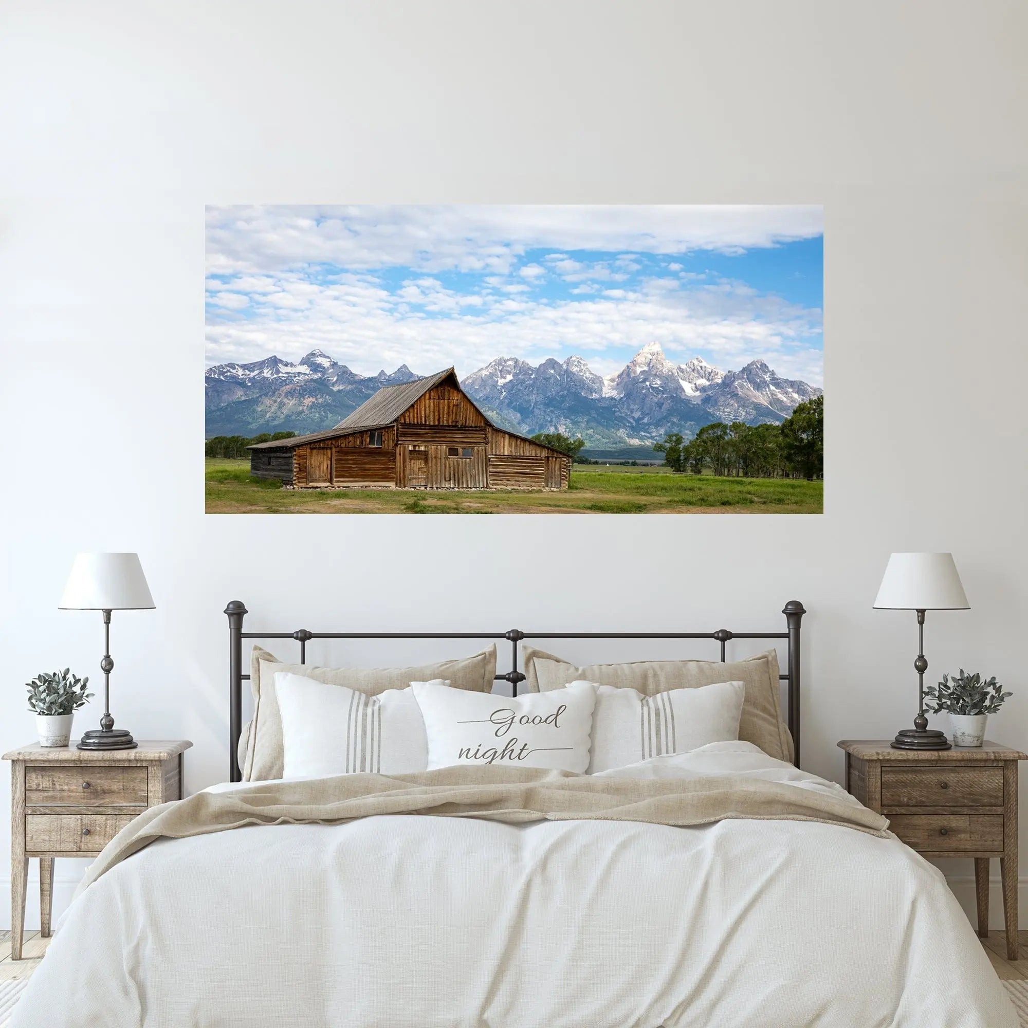 TA Moulton Barn wall art hanging above a light, cozy bedroom setup with neutral bedding and matching nightstands.