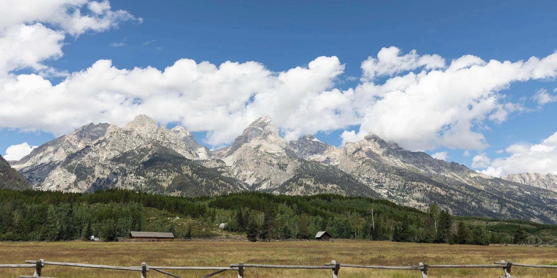Teton Valley Wyoming landscape art with clouds in the sky and wooden fence lining the field