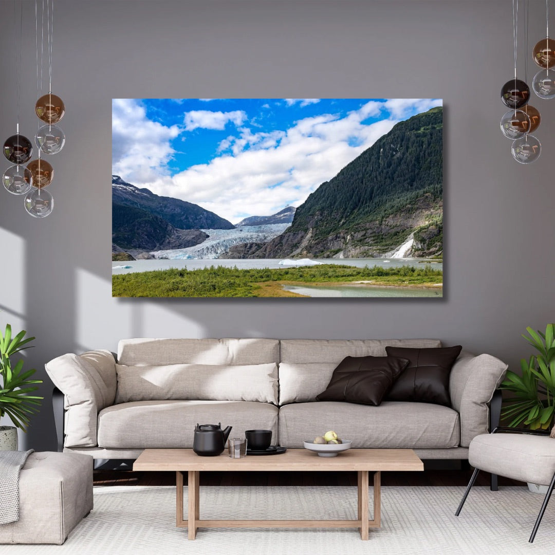 Living room with a large statement piece art of Mendenhall glacier displaying a mountain landscape, beige sofa, and wooden coffee table.