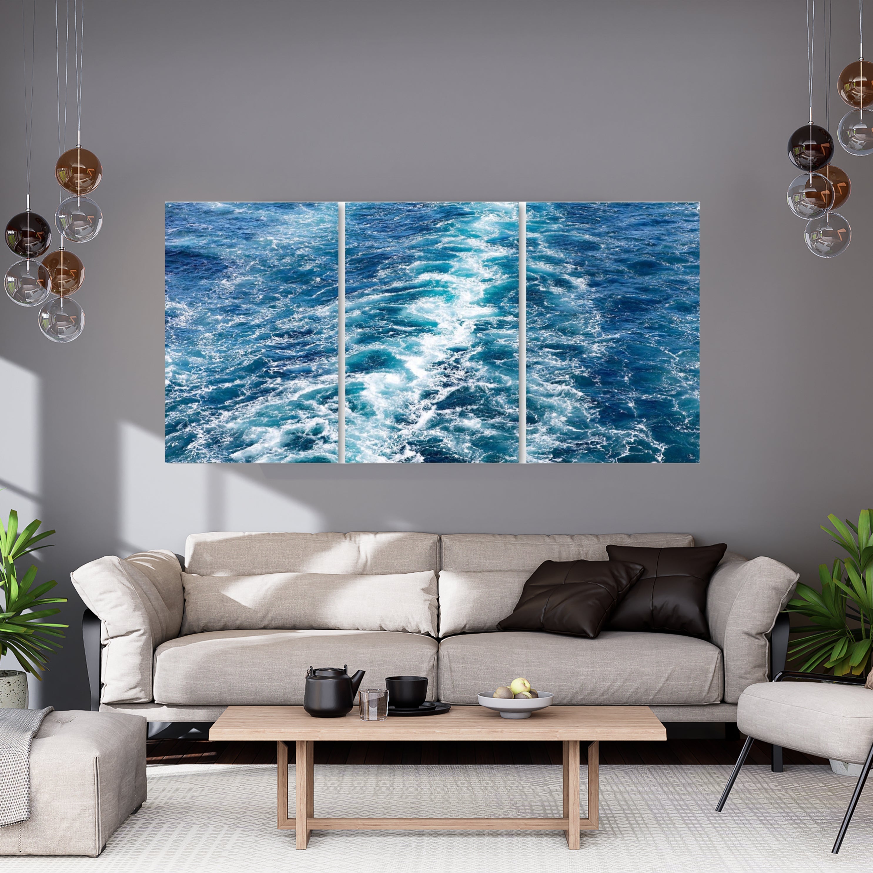Large blue ocean wave wall art displayed above a neutral modern sofa — abstract teal and blue water texture adding a calming coastal feel.