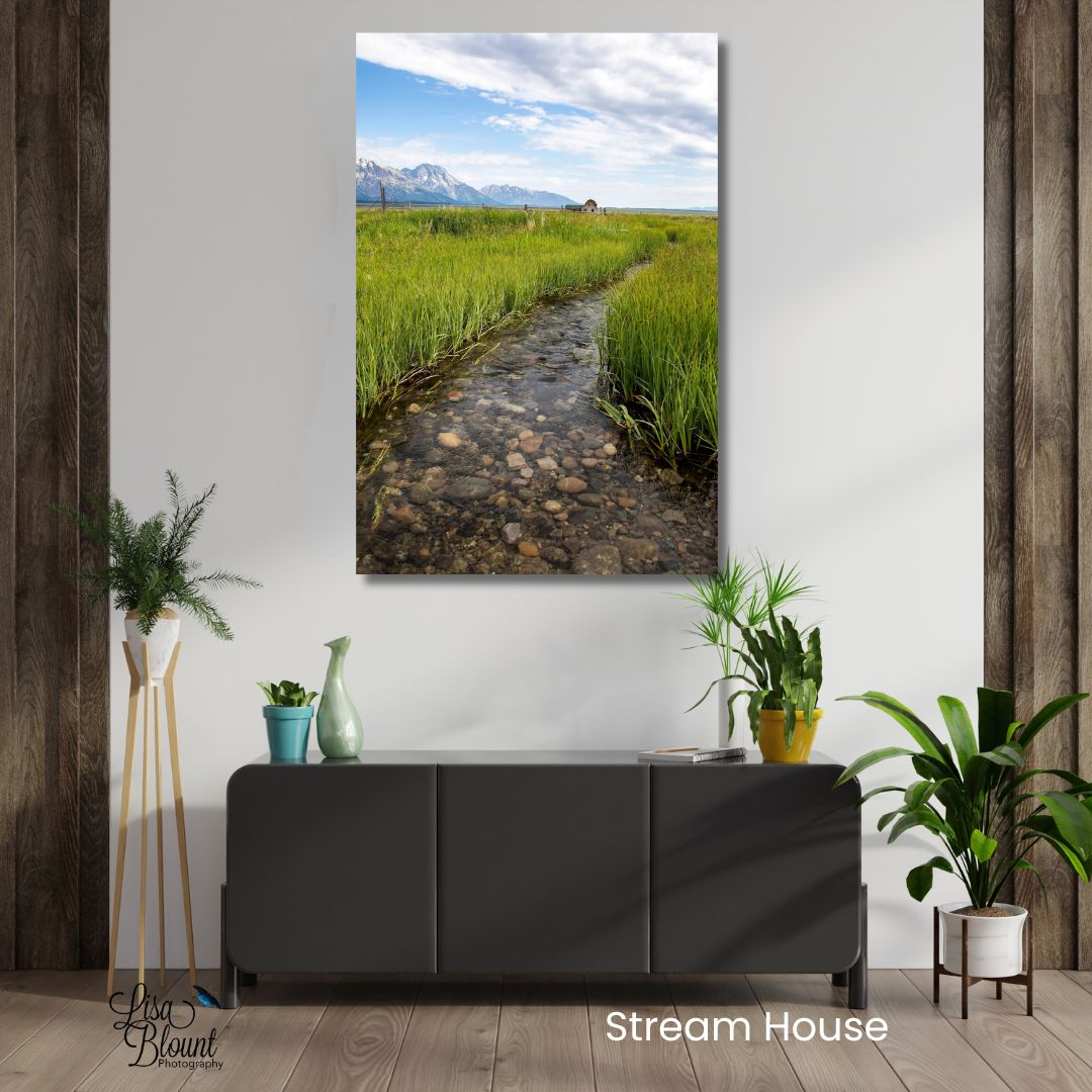 Grand Teton wall art featuring a stream, rustic barn, and mountain landscape at Mormon Row styled above a dark console in a modern rustic room