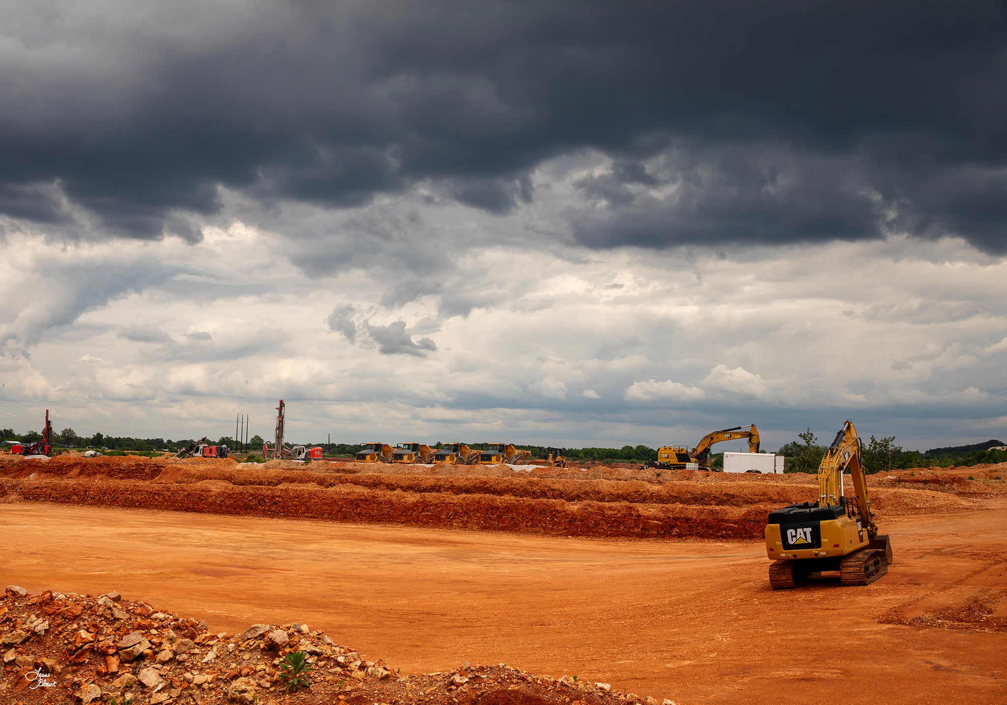 Northwest Arkansas construction wall art featuring heavy equipment at Sharp’s APAC Quarry beneath dramatic storm clouds by Lisa Blount.