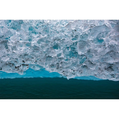 Elongated art of cold iceberg in spencer lake Alaska featuring detailed ice crystals and teal water