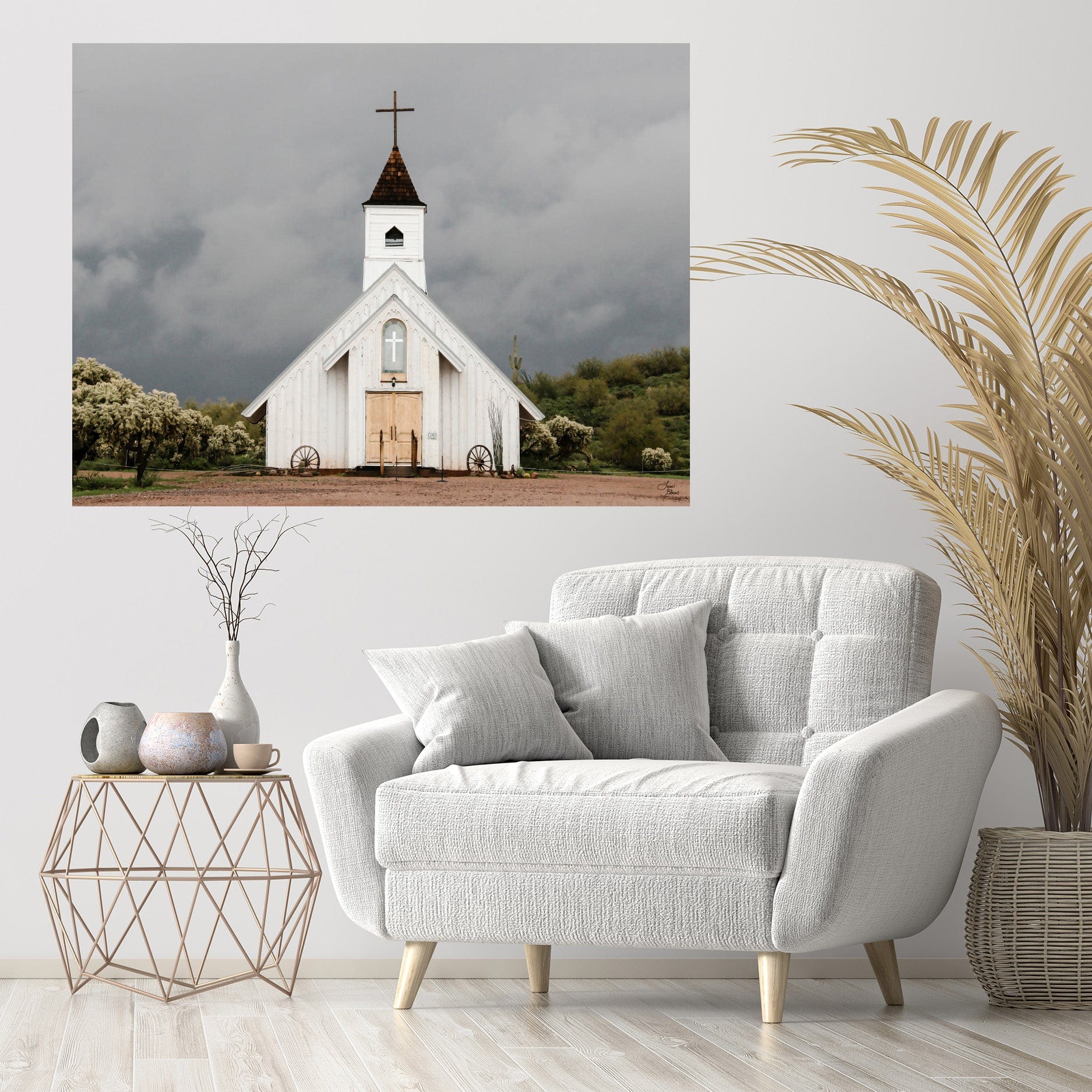 White country church wall art titled “Spiritual Warfare” hanging above a cozy cream armchair, styled with neutral décor and greenery.