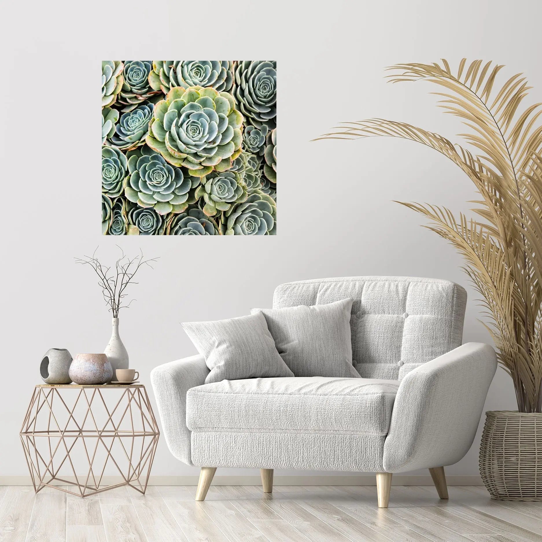 Green succulent fine art print displayed above a light gray chair in a soft neutral living room with pampas grass decor.
