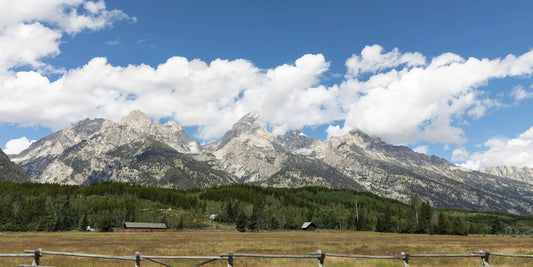 Teton Valley Wyoming landscape art with clouds in the sky and wooden fence lining the field